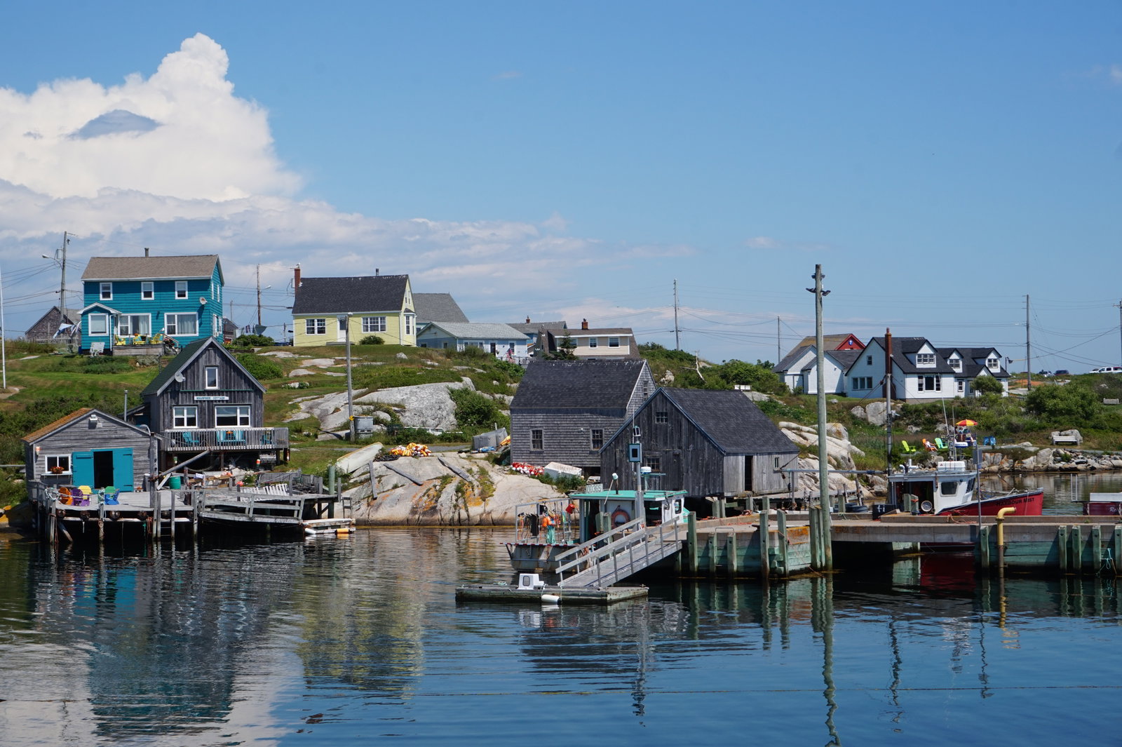 Cruise ship docked at a waterfront in Sydney, Nova Scotia, with a large fiddle sculpture nearby.