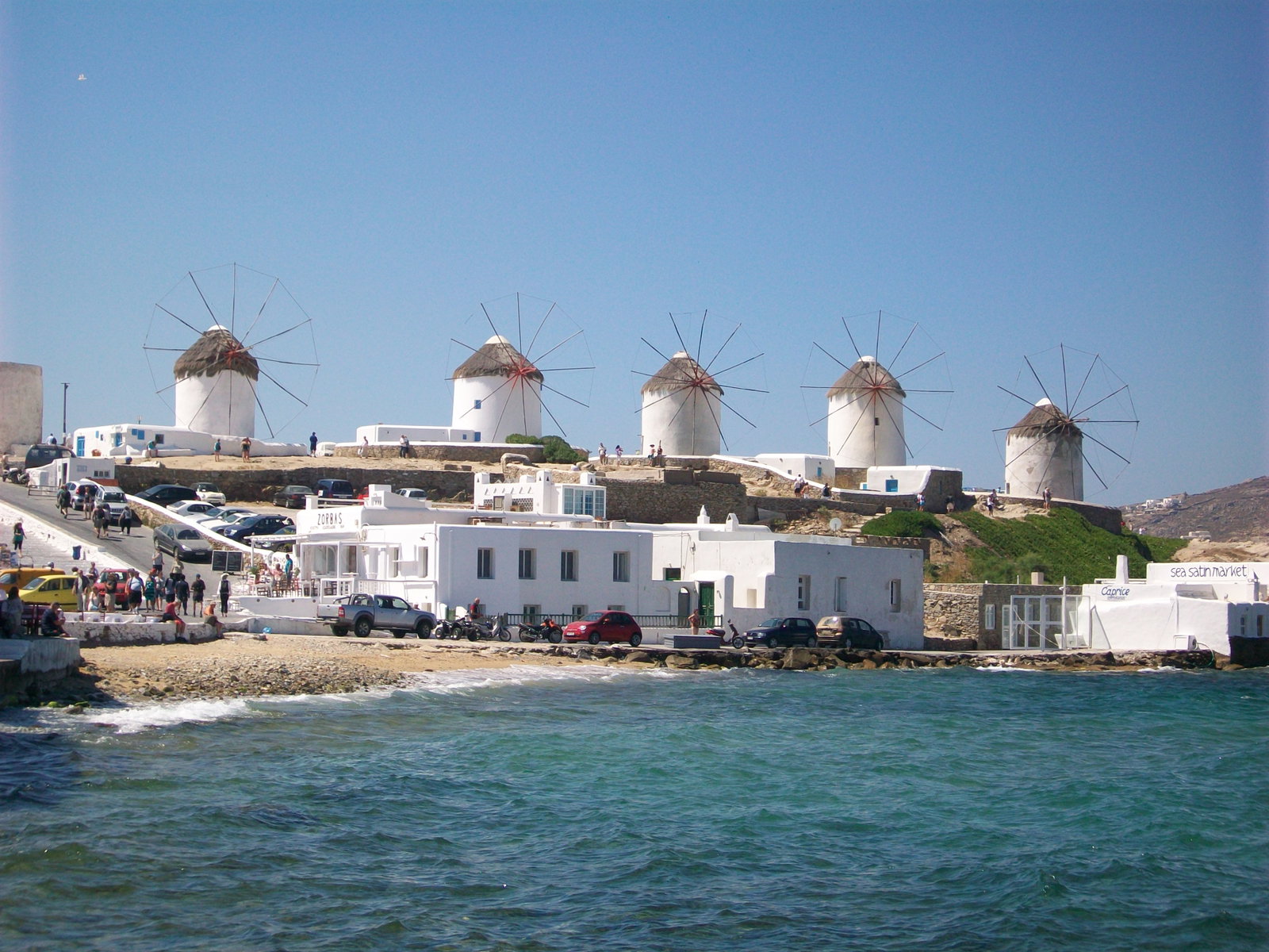 View of the small port of Katakolon with a cruise ship docked and a glimpse of the Greek coastline.