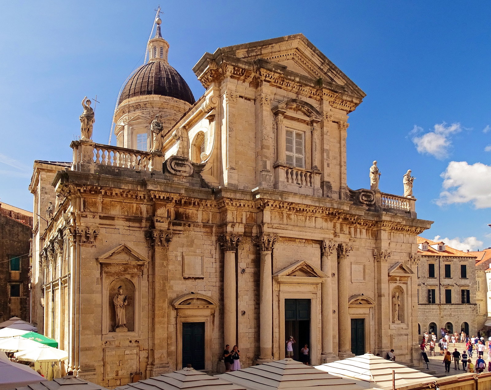 A panoramic view of Dubrovnik's Old Town with orange-tiled roofs, ancient walls, and the Adriatic Sea.