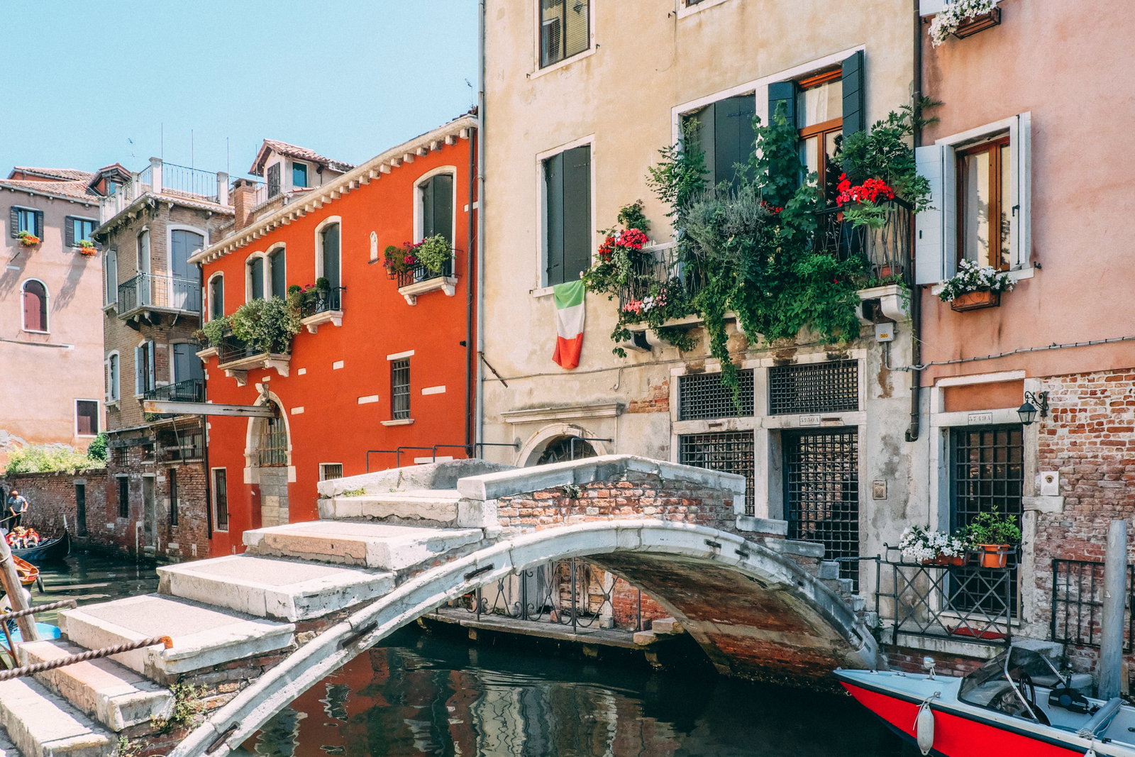 Colorful gondolas floating on a Venetian canal with historic buildings.
