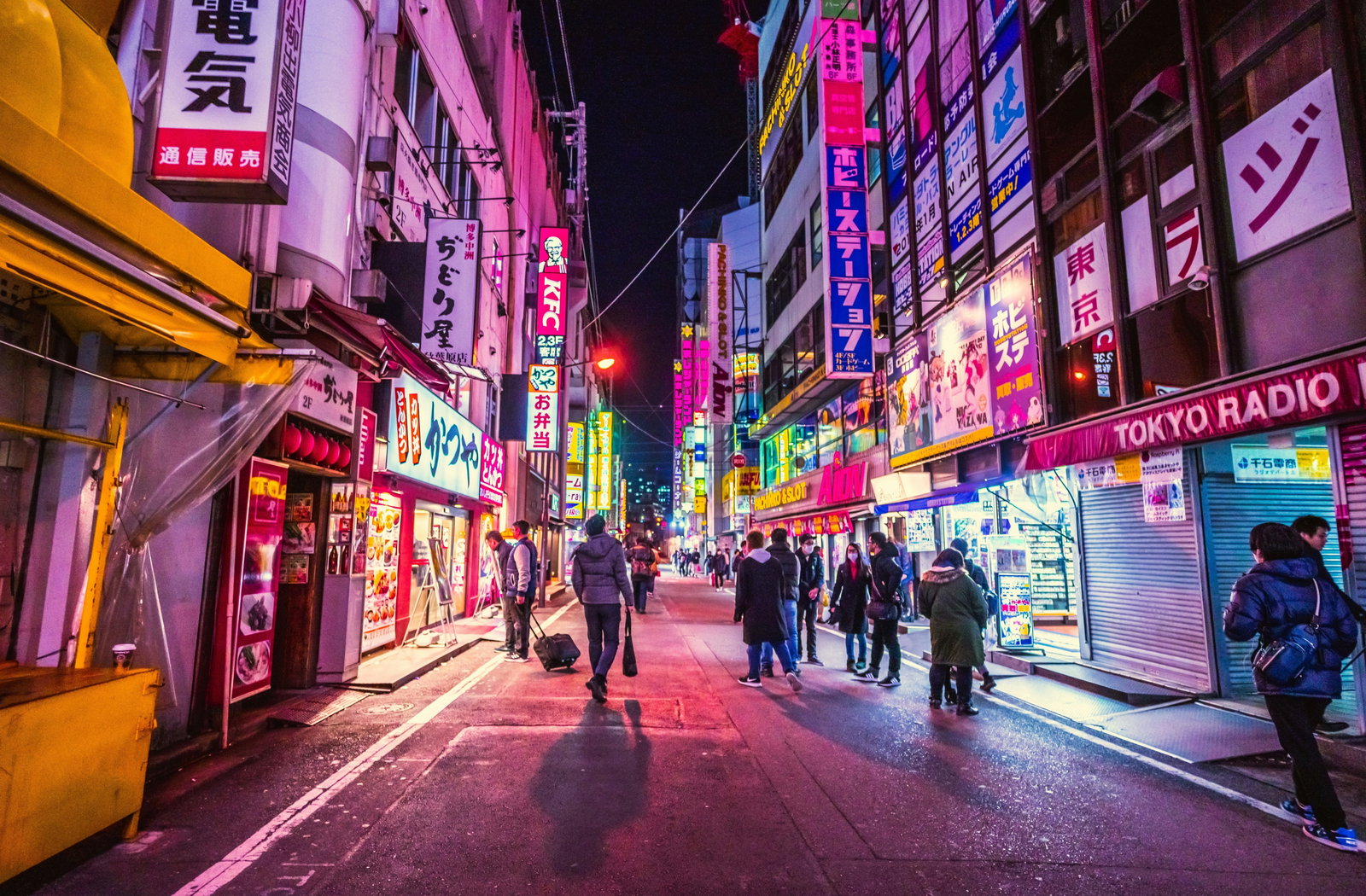 Lively Tokyo street scene with neon lights and bustling crowds at night