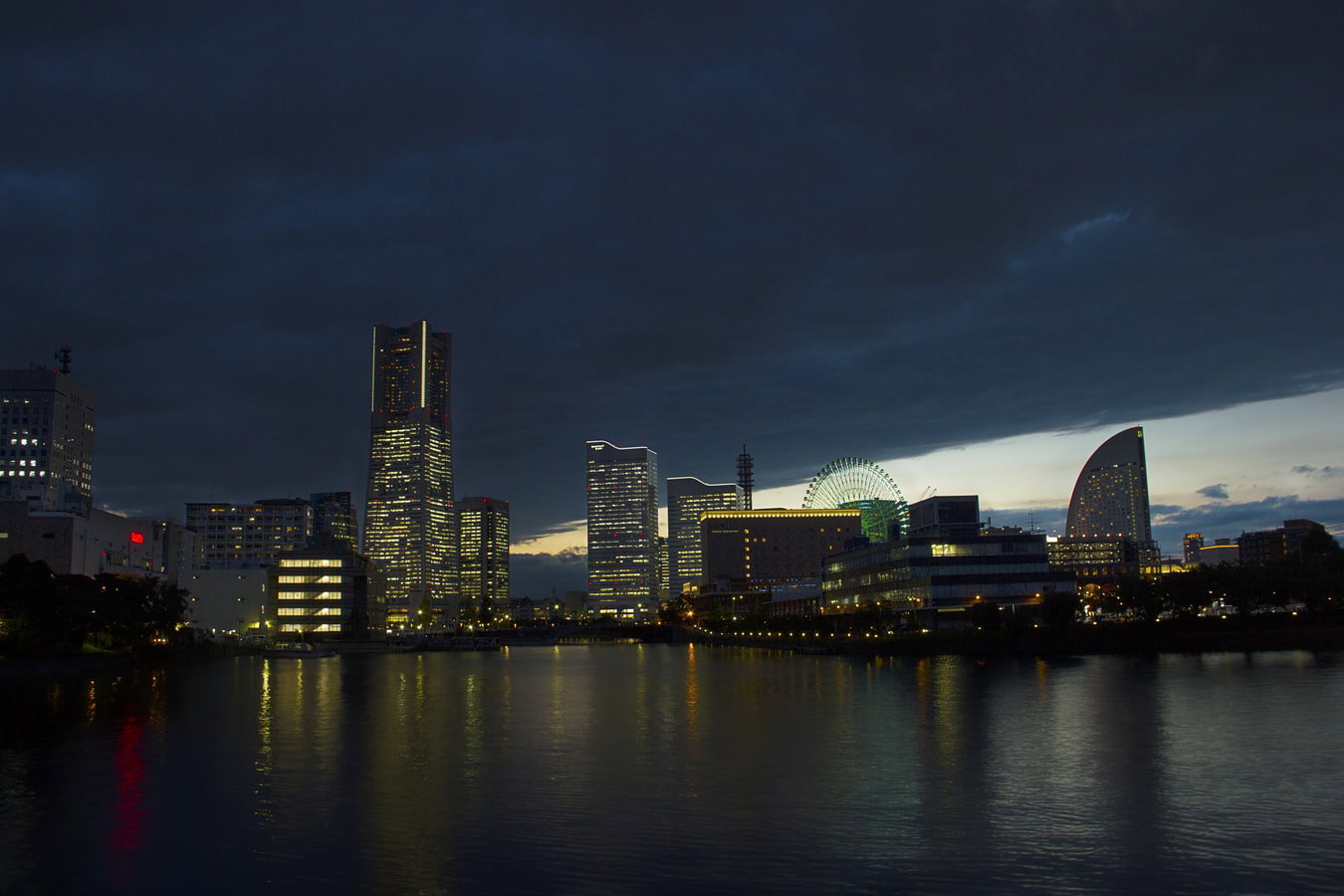 A bustling waterfront scene in Yokohama, Japan, with modern buildings and ships.