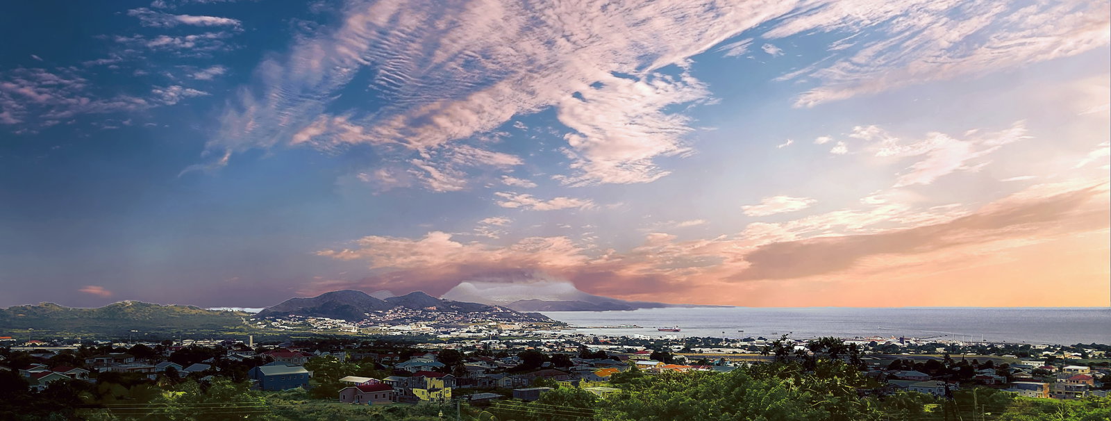 Lush green mountains of Saint Kitts rising above clear blue Caribbean waters.