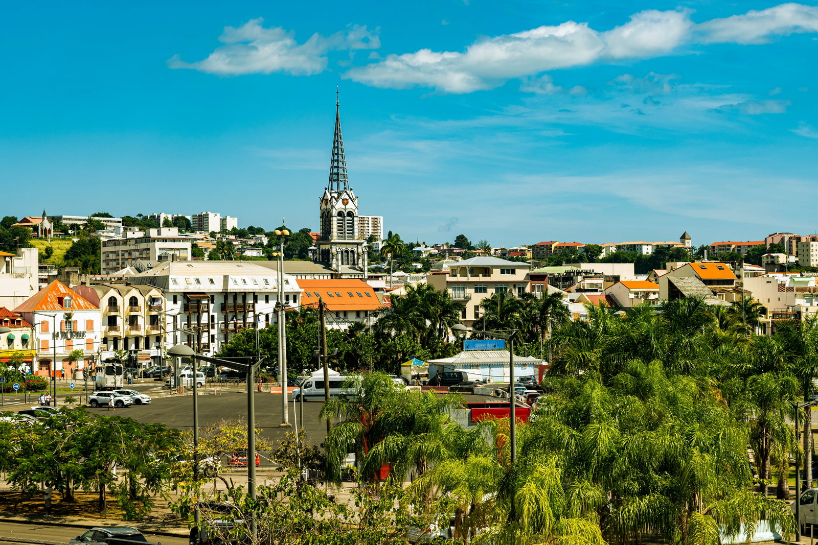 A bustling street market scene in Fort-de-France, Martinique, under blue skies.