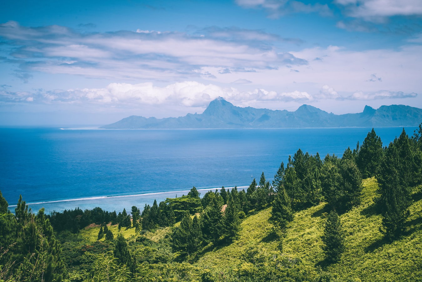 Cruise ship docked in Papeete harbor with lush green mountains and turquoise water in the background