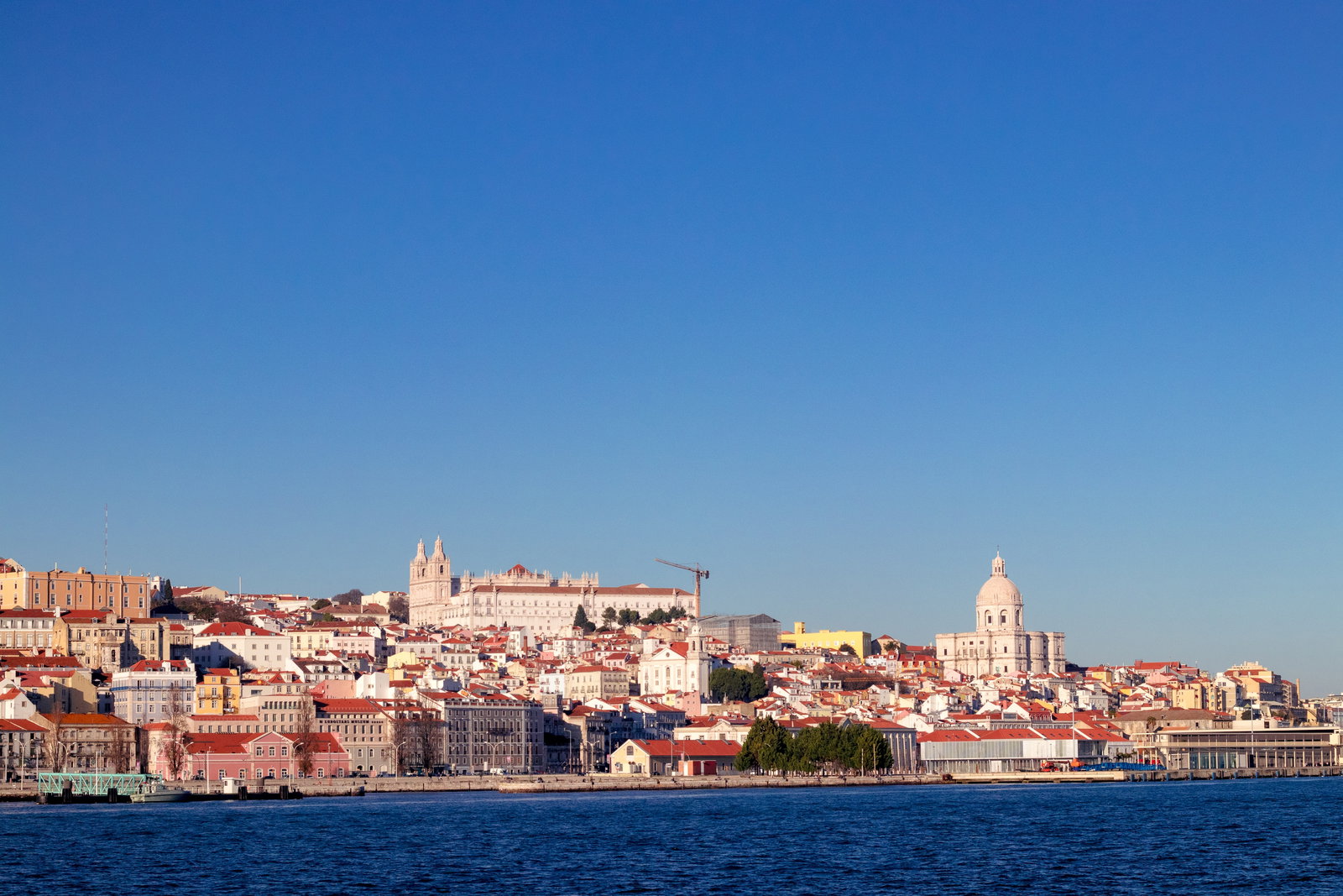 Historic Lisbon cityscape with a cruise ship docked on the River Tagus.