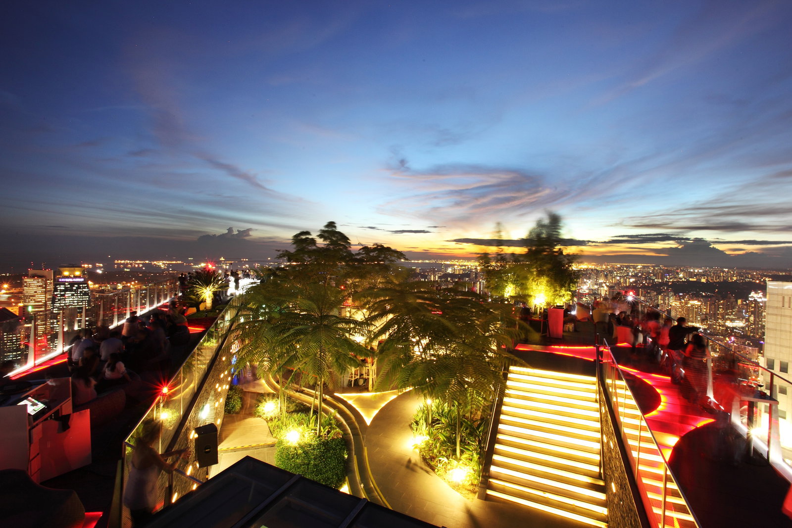 Modern Singapore skyline with futuristic supertrees and city buildings at sunset.