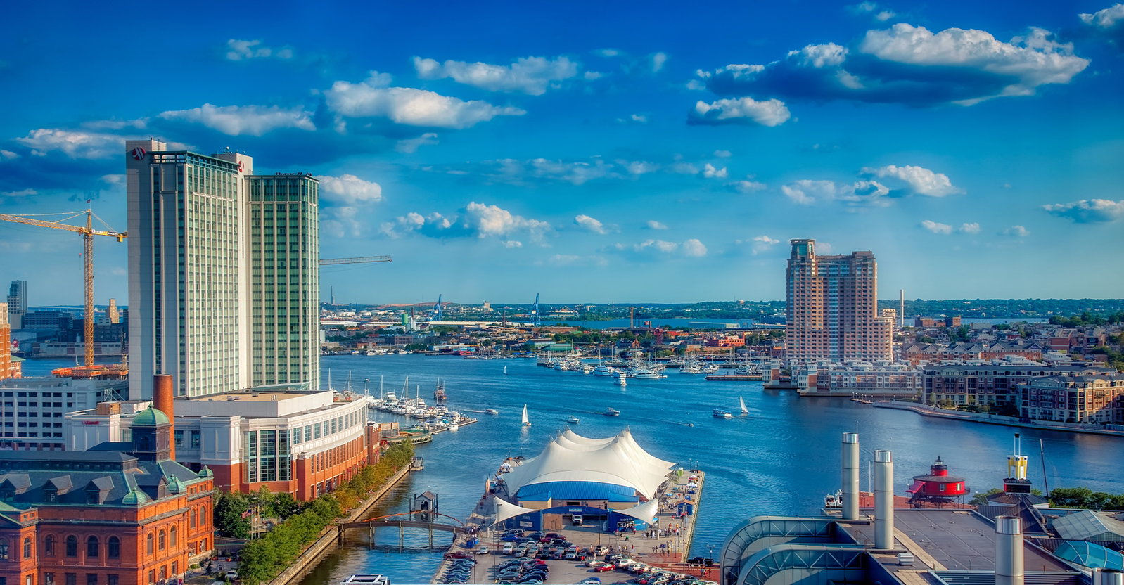 Historic ships docked in Baltimore's Inner Harbor with city buildings in the background.