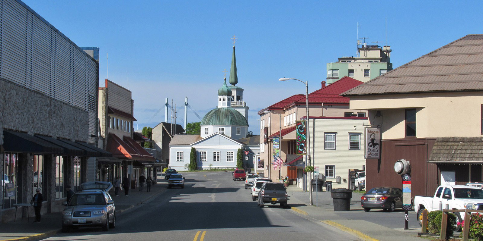 Historic St. Michael's Cathedral in Sitka, Alaska, with mountains and water in the background.