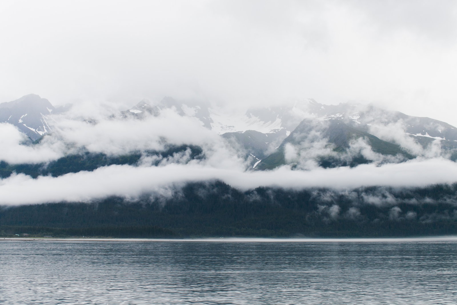 A cruise ship docked in Seward, Alaska, with mountains and water in the background.