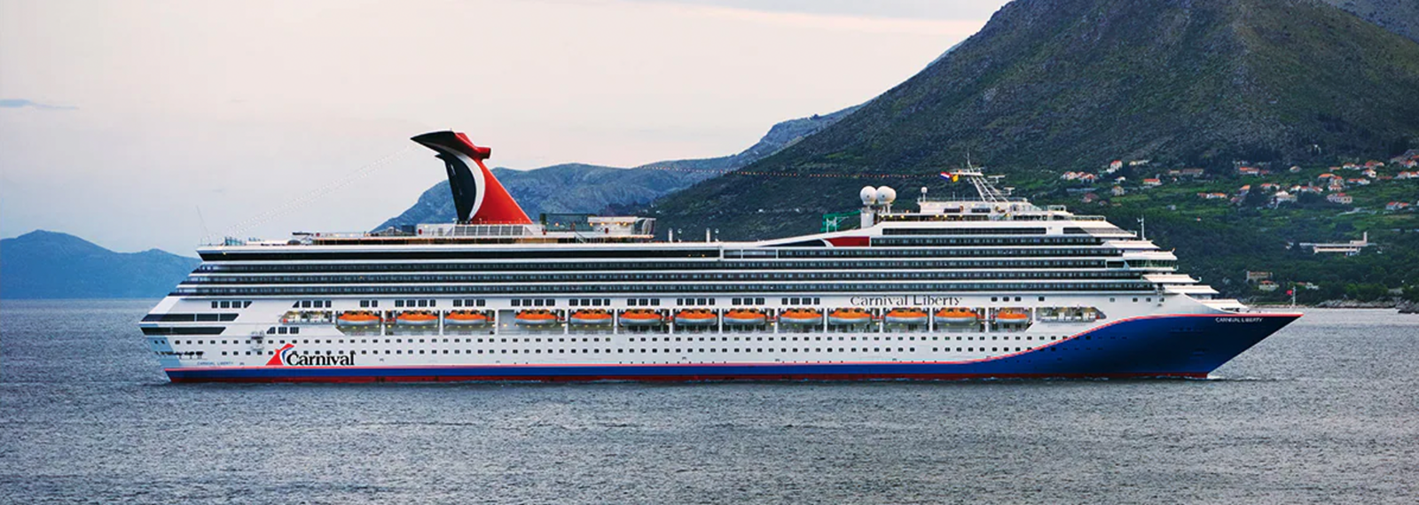 A large cruise ship sailing on calm blue waters under a clear sky.