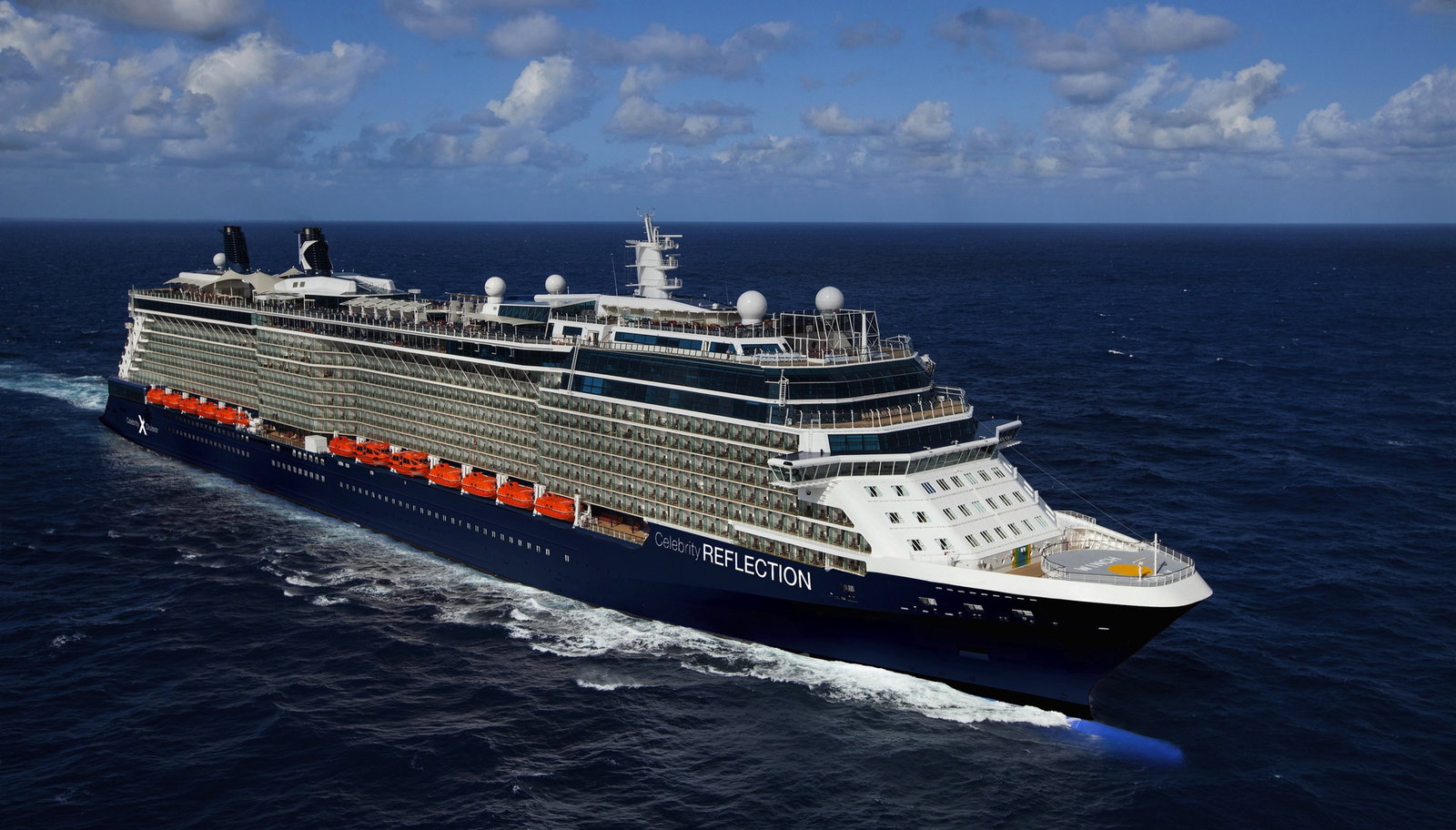 The Celebrity Reflection cruise ship sailing on blue waters under a clear sky.