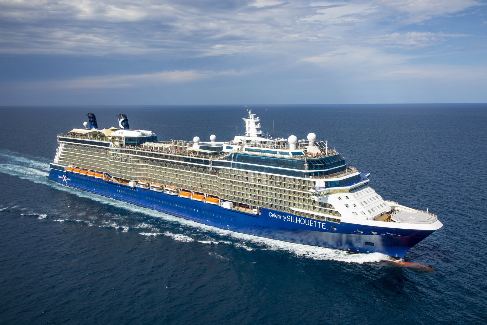 Guests relaxing on the real grass lawn deck of Celebrity Silhouette with ocean views.