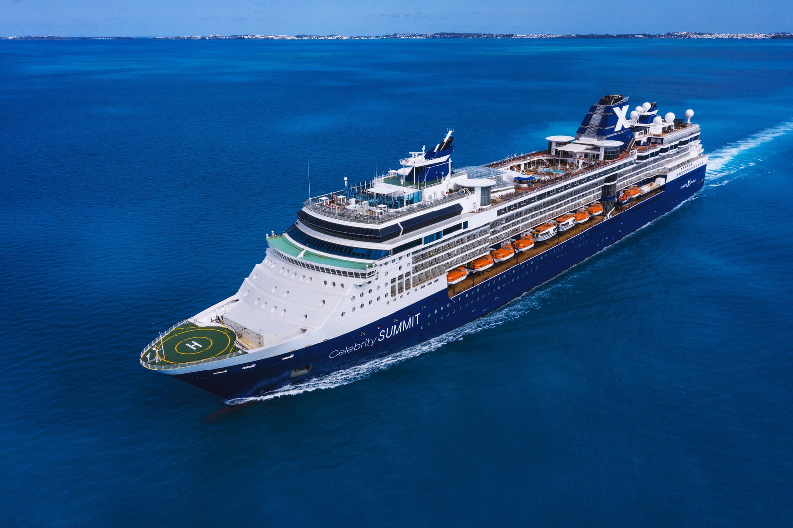 A Celebrity Summit ship sailing on calm blue waters under a clear sky.