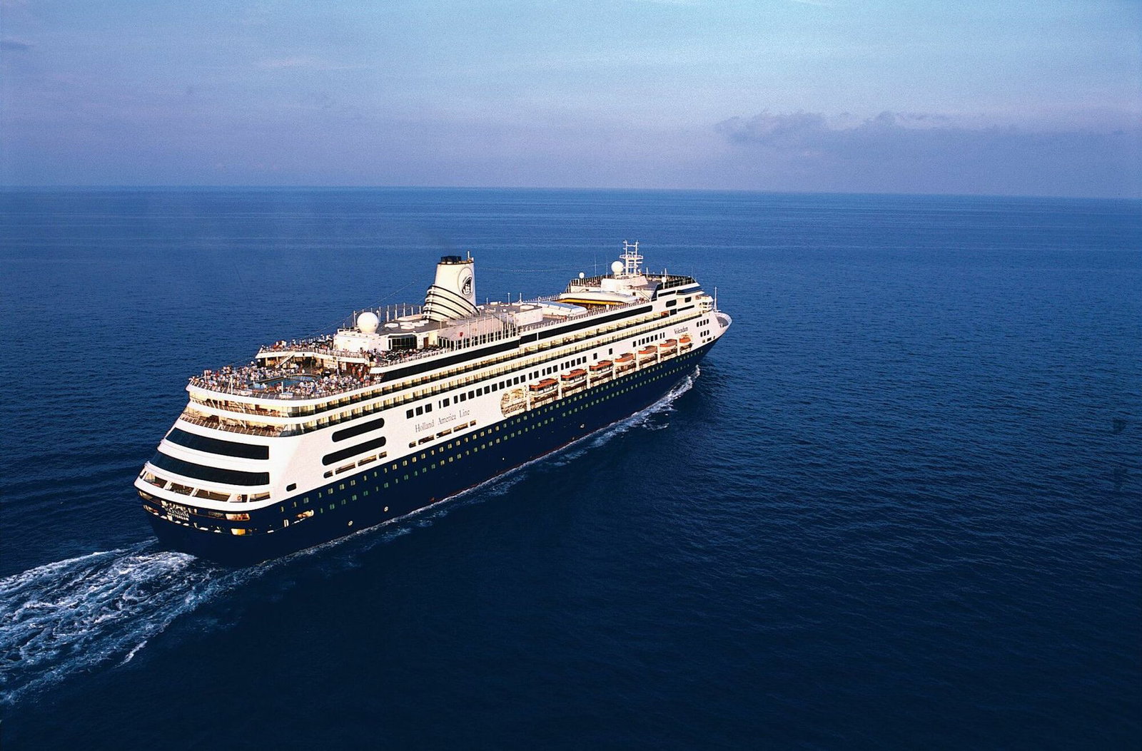 Holland America Line Volendam cruise ship sailing on calm blue waters.