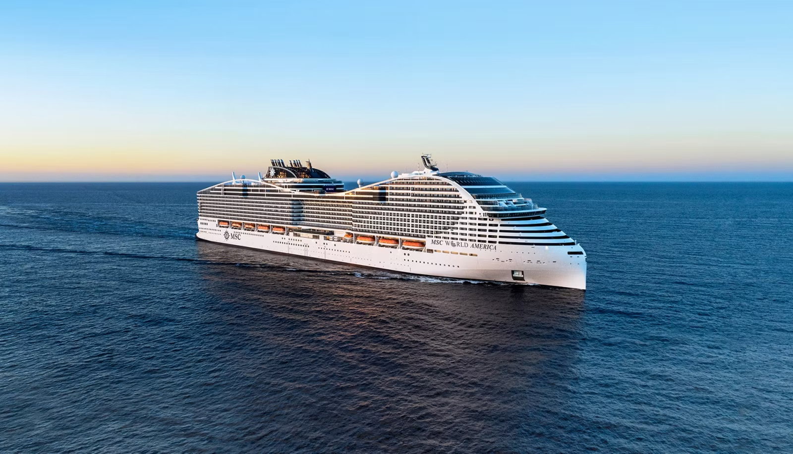 Large cruise ship sailing in the Caribbean with a vibrant waterpark and promenade.