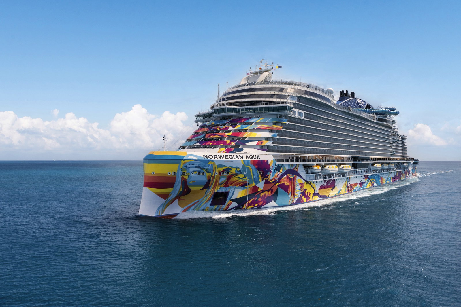 Cruise ship Norwegian Aqua sailing on clear blue waters under a sunny sky.