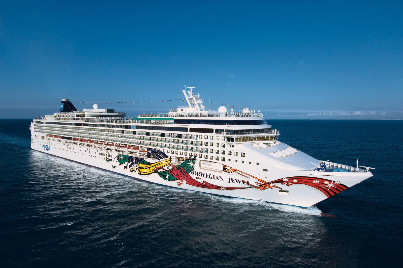 Norwegian Jewel cruise ship sailing on calm blue waters under a clear sky