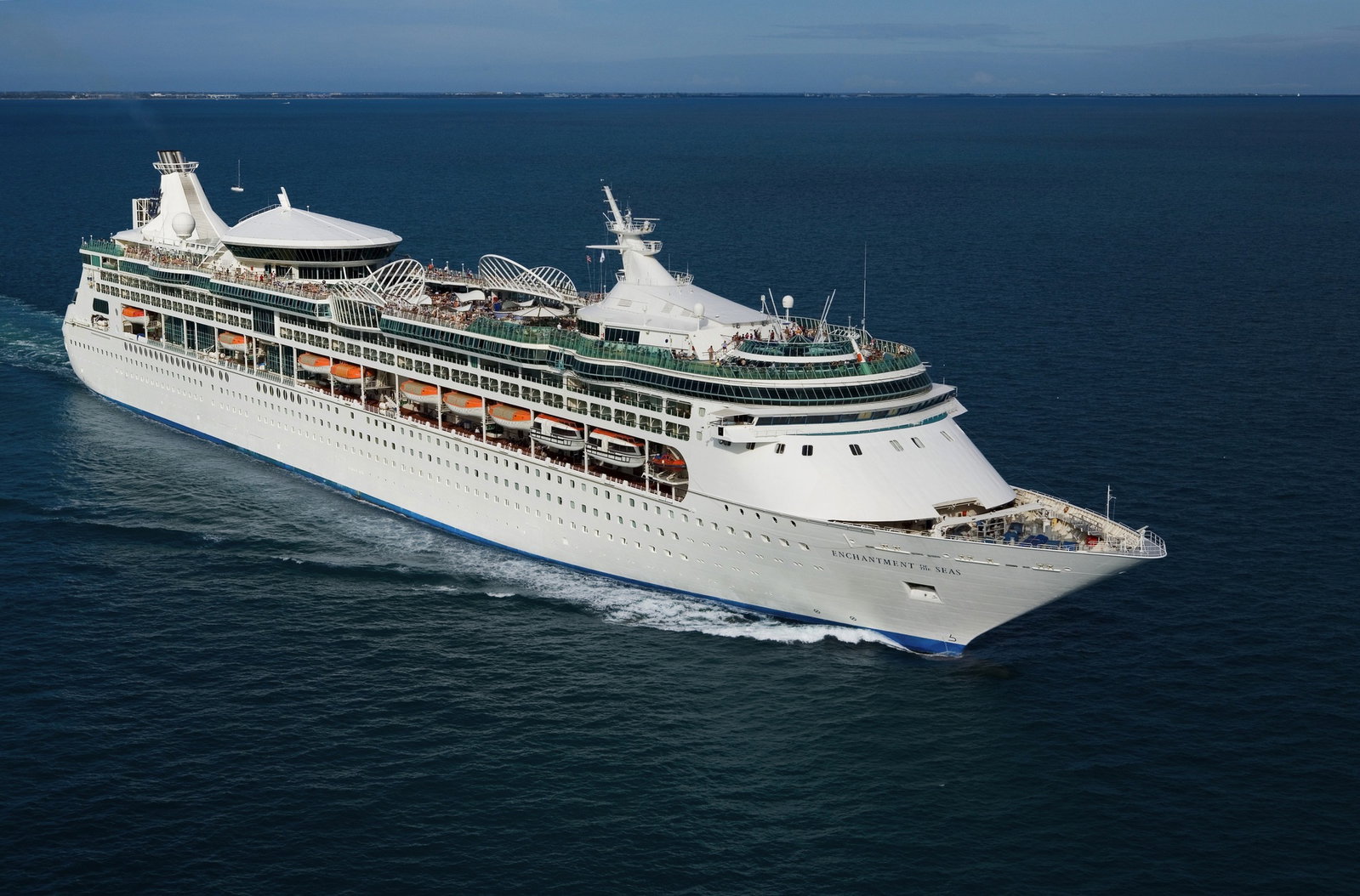 Royal Caribbean cruise ship sailing on blue ocean waters at sunset